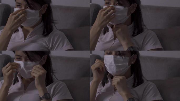 4k亚洲沃金妇女戴上白色面具，坐在沙发上，白衬衫上衣，医用防护面具，埃博拉MERS传染性非典型肺炎，