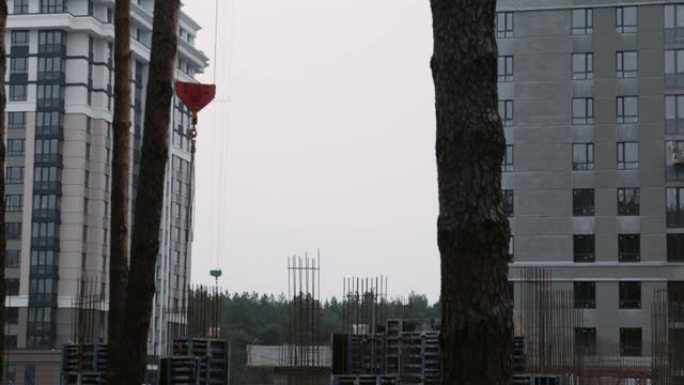 建筑起重机吊装混凝土大型建材，特写。建造新公寓。绿地正在建设中的摩天大楼