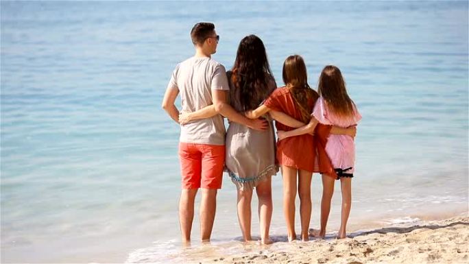 年轻的四口之家在海滩度假