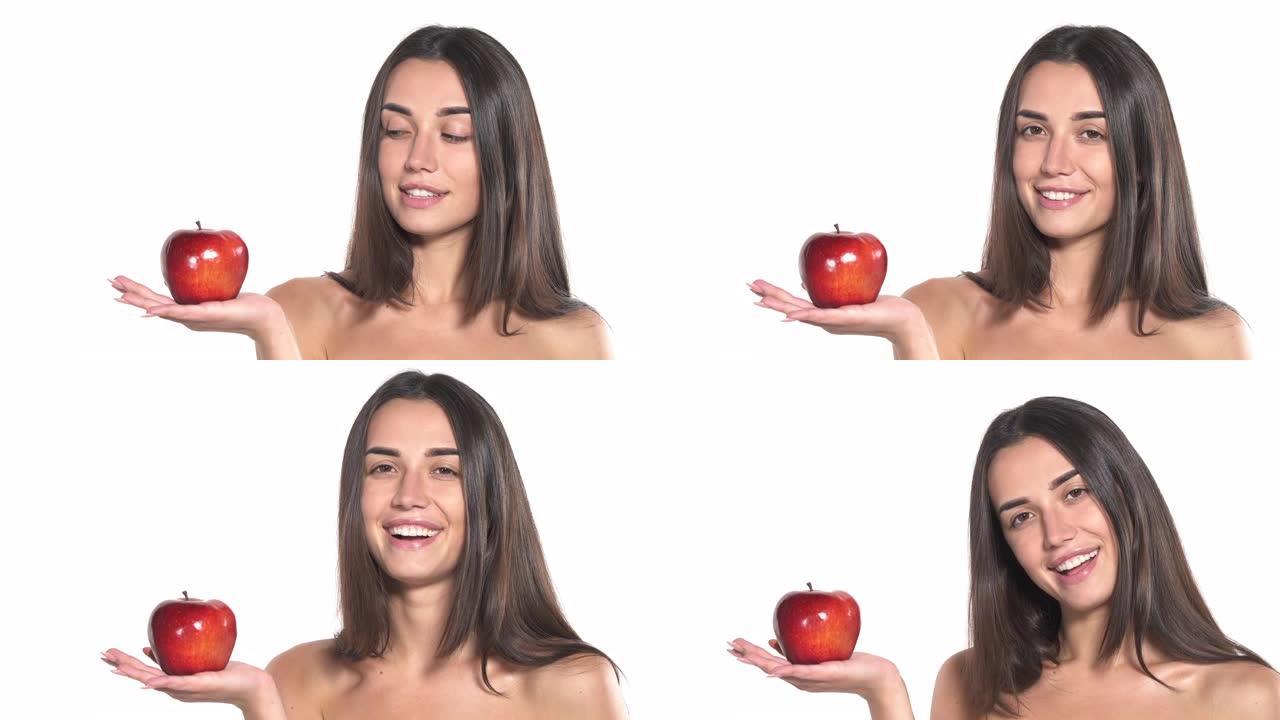 年轻裸女捧着红多汁的苹果微笑着。健康的生活方式。孤立，在白色背景上。本空间