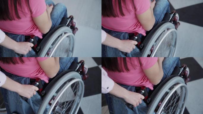 年轻女子帮助坐轮椅的人在家