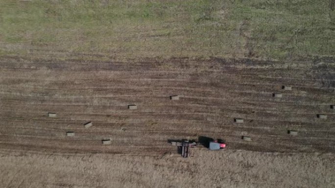 鸟瞰图农场工人收获携带圆形圆柱形稻草堆