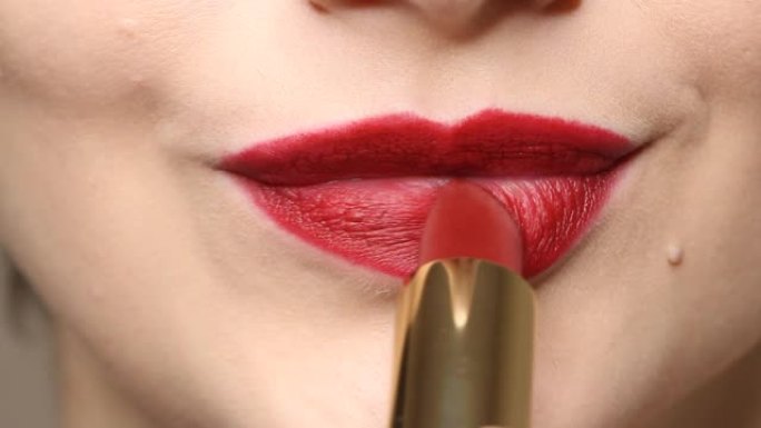 女人在嘴唇上涂上深红色唇膏。美丽与时尚概念的特写视图