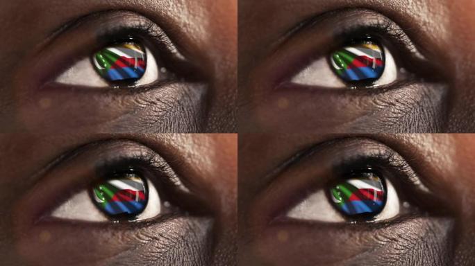 女子黑眼睛在近距离与旗帜科摩罗虹膜与风运动。视频的概念