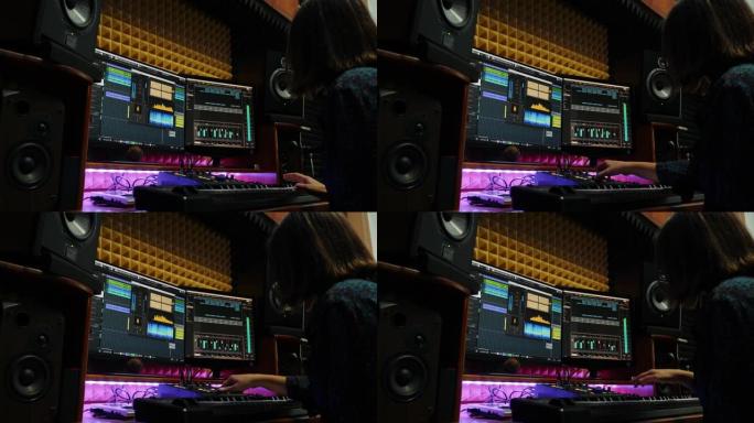女曲作者在专业录音棚的屏幕上使用监视器和均衡器混合装置创作歌曲。女人在音响音乐工作室玩电子钢琴、混音