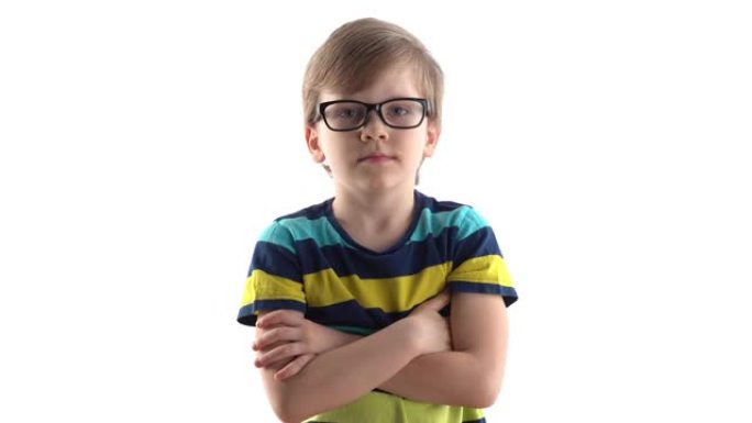 一个严肃男孩在白色背景上的工作室肖像。带眼镜的一年级生
