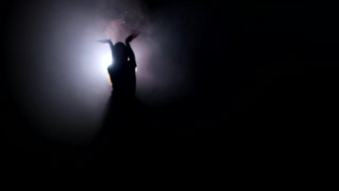 剪影年轻女子在黑暗中跳舞