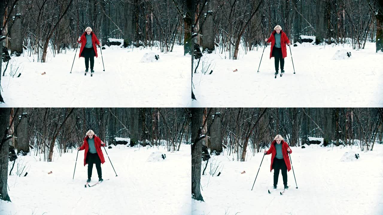 一个穿着红色羽绒服的年轻金发女子在森林里滑雪行走