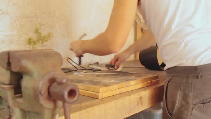 木匠在复古的老式车间里在旧木头上工作。