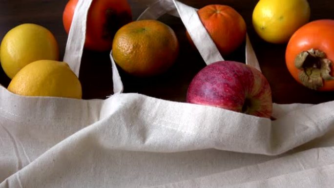 带有水果产品的生态袋。零废物使用更少的塑料概念。木质桌子上的生态棉布袋有机新鲜水果