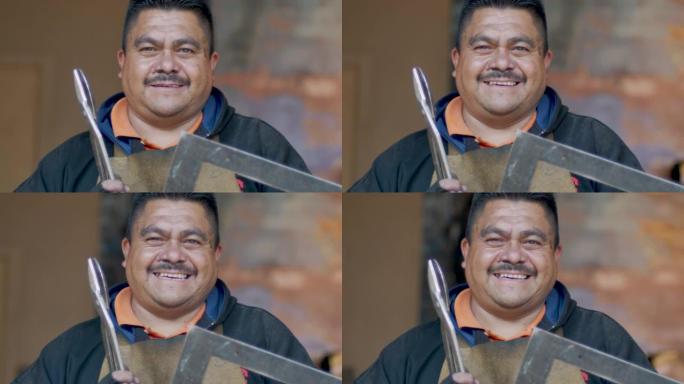 墨西哥或西班牙裔男子拿着工具微笑着看着相机