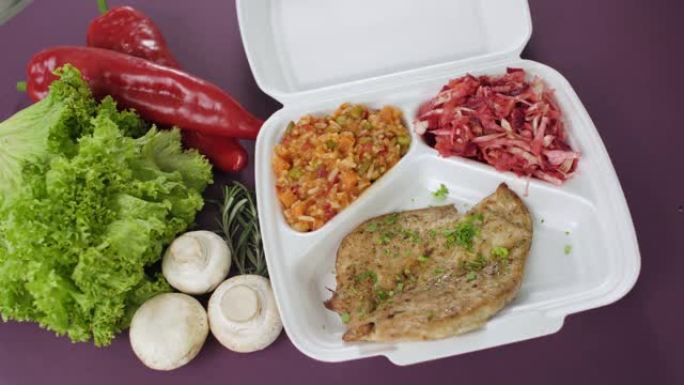 将外卖食品包装在聚苯乙烯泡沫塑料盒中。新鲜送货套餐，鸡胸肉，米饭，蔬菜和沙拉