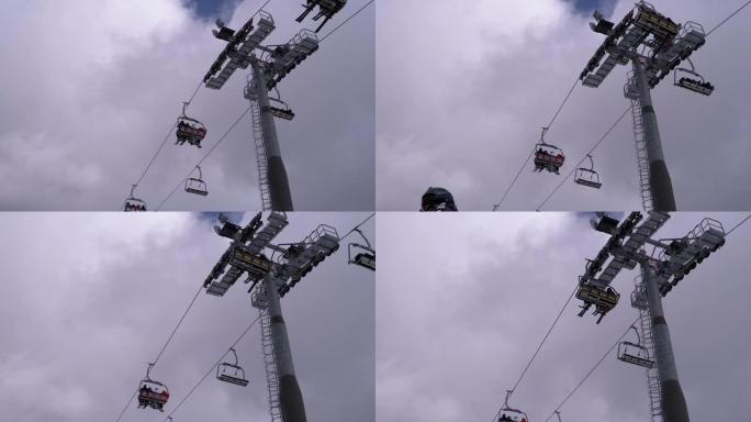 滑雪缆车与滑雪者在蓝天和云的背景。滑雪胜地