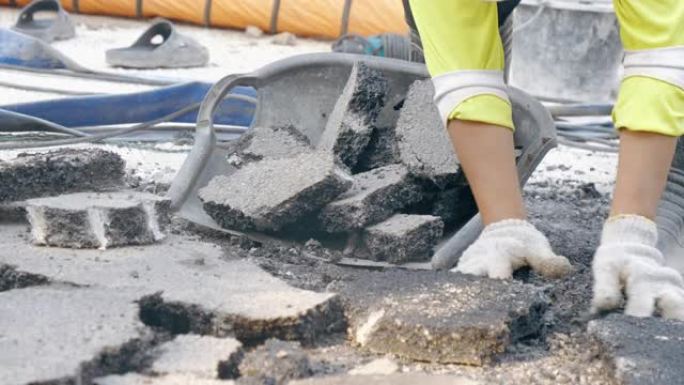 道路施工现场的一名工人用气动手提钻拆除沥青