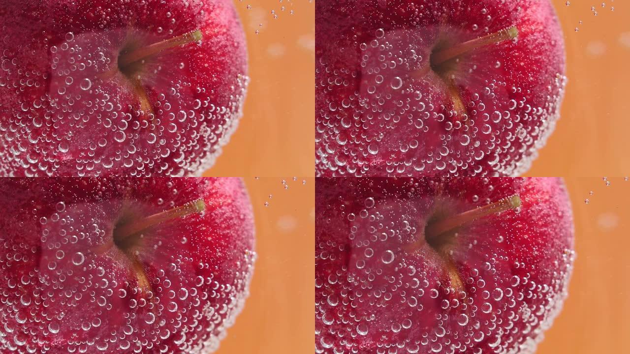 成熟多汁的红苹果在水下选择性聚焦特写宏观水中。水中的水果