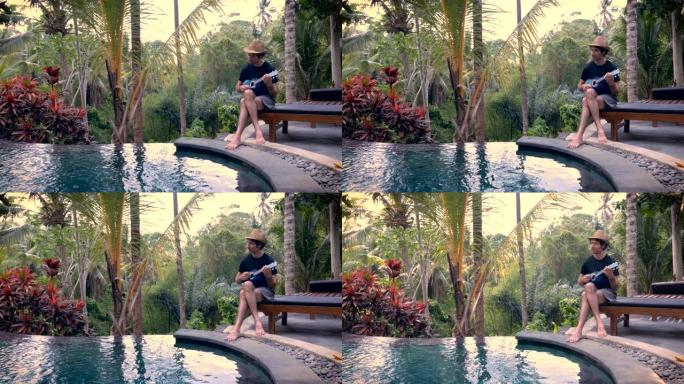 一个中年男子在丛林的游泳池边弹奏尤克里里琴的广角镜头