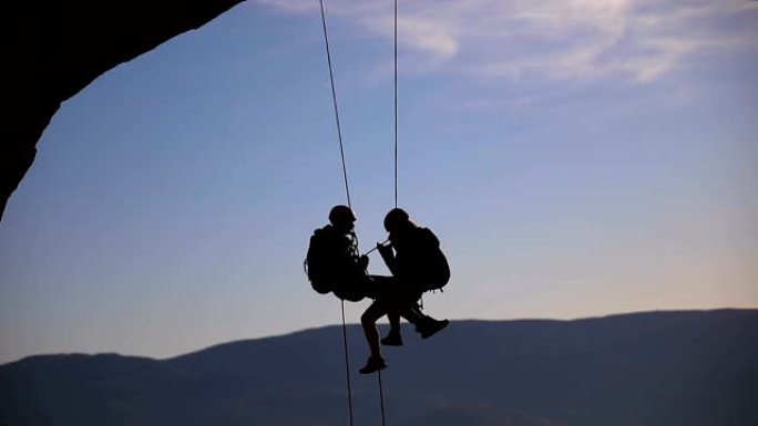 夫妻在山顶上的绳索登山队