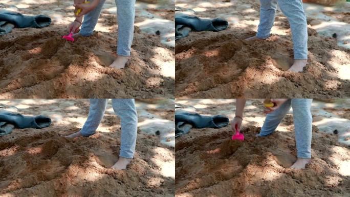 孩子站在沙堆上，用铁锹铲沙