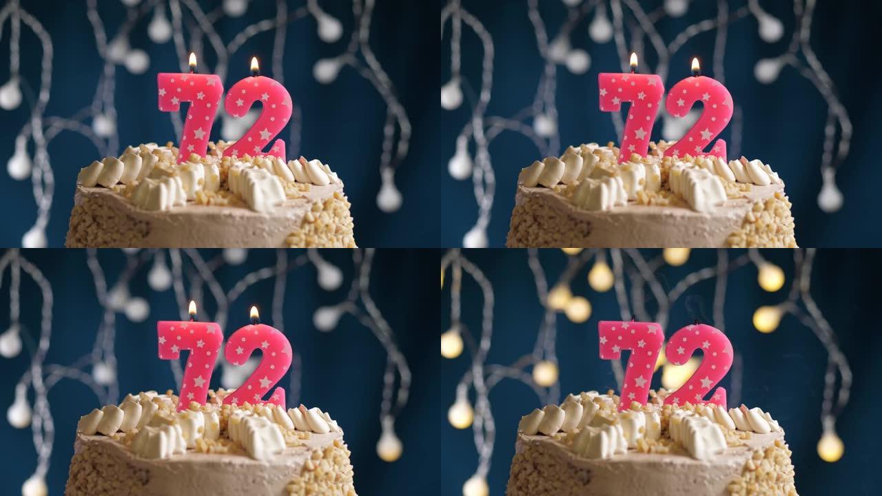 蓝色背景上有72号粉色蜡烛的生日蛋糕。蜡烛吹灭了。慢动作和特写视图