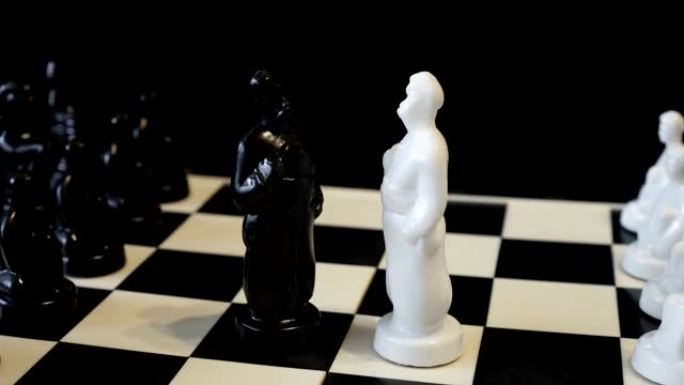 黑白棋盘上的白色和黑色棋王的身影彼此相对。斯拉夫男子-哥萨克形式的棋子。特写。轮动。概念。4K
