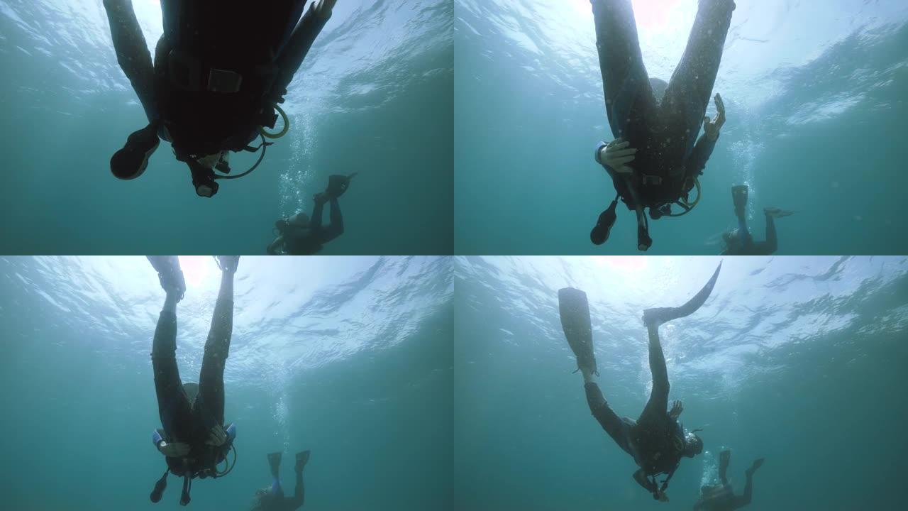 男性水肺潜水员在海洋深处的开阔水域游泳。
