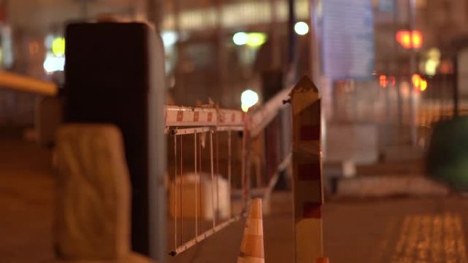 夜间城市街道上的自动道路屏障门。夜间城市灯光模糊