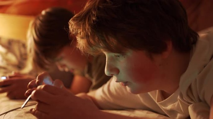 两个十几岁的男孩深夜在卧室玩电脑游戏