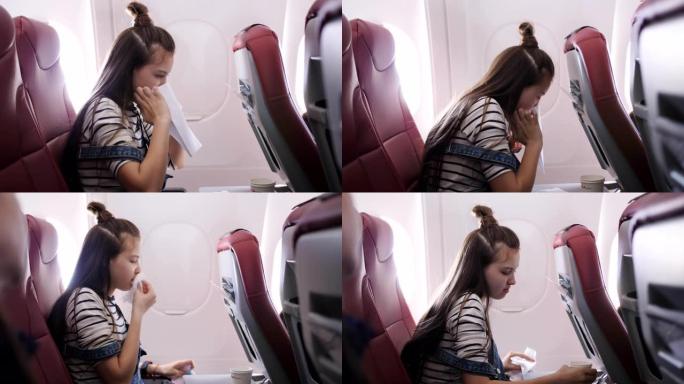 飞机上的少女在纸袋里呕吐。乘坐飞机的旅行者恶心。恶心飞机上的乘客。飞机上的湍流。