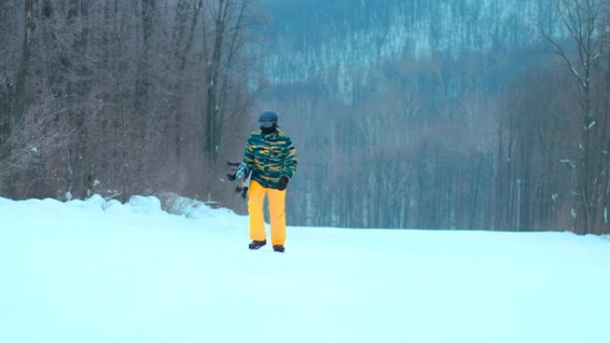 男子用滑雪板爬山。男人带着滑雪板去，要去骑。美丽的冬季风景。