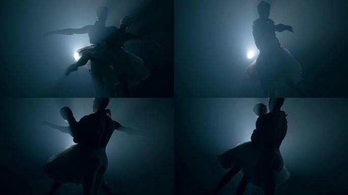 优雅的芭蕾舞演员和她的男性伙伴在黑暗中与泛光灯背光跳舞的古典或现代芭蕾舞元素。一对夫妇在黑色背景的烟