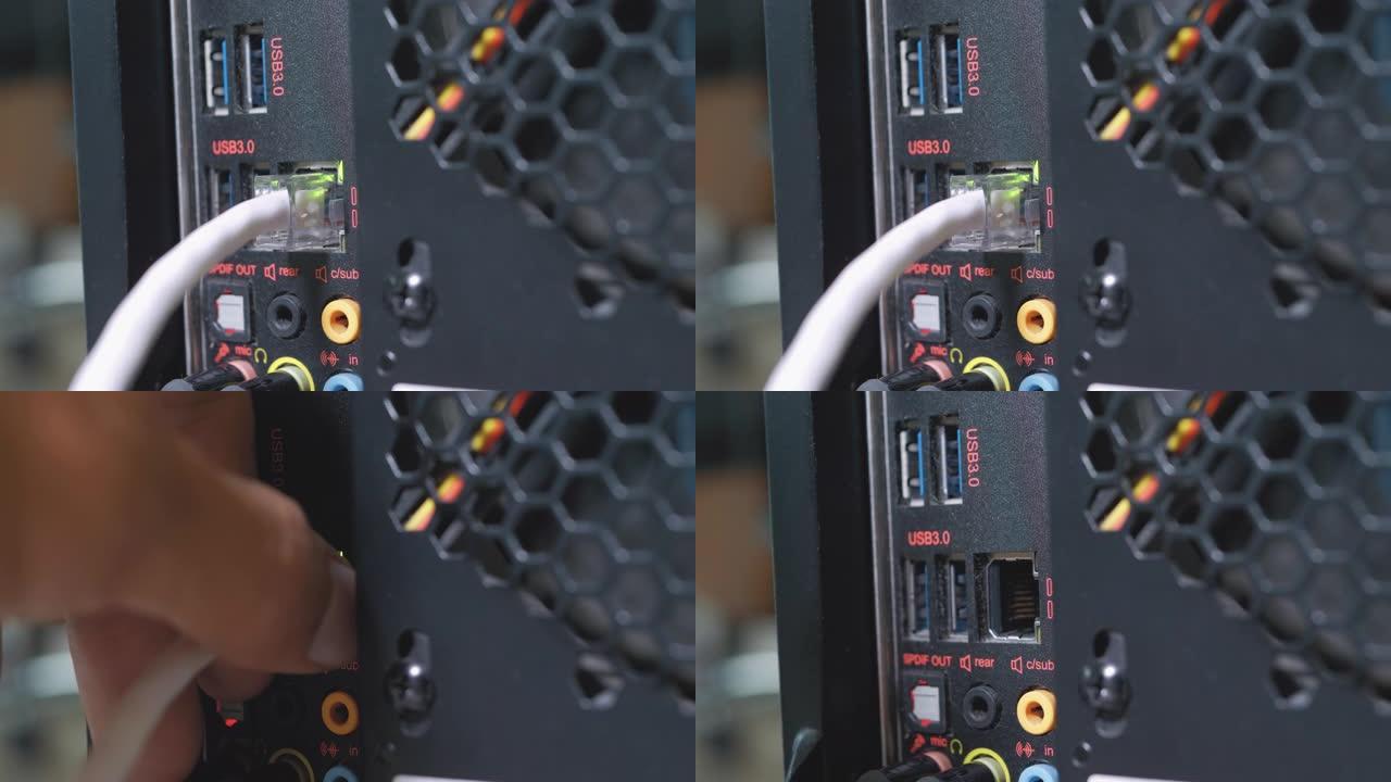 人的手在计算机端口中插入并插入usb 3电缆，LAN电缆，音频和麦克风电缆。