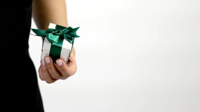 一名妇女在带有绿丝带的白色礼品盒中赠送礼物