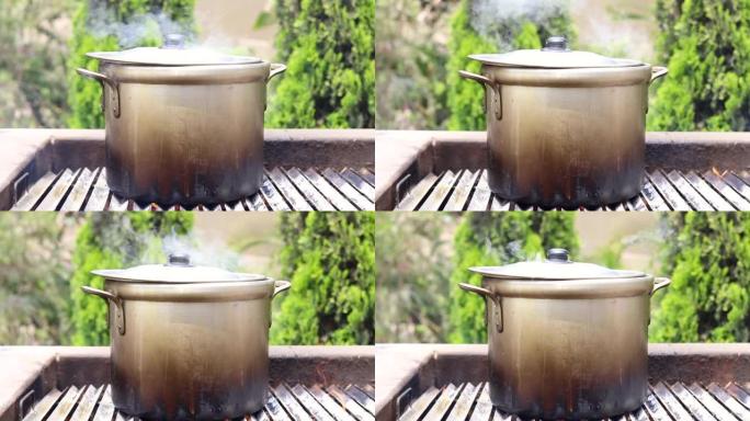 在锅里准备汤，在自然界中。通过柴火煮汤