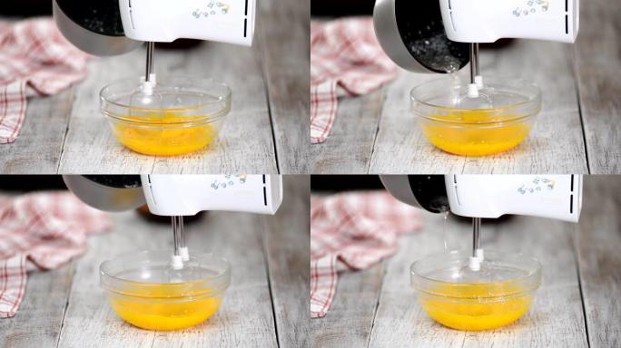 Cook confectioner逐渐将热糖浆添加到蛋黄中。