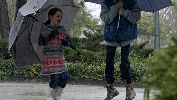 男孩和一个女孩在慢动作的倾盆大雨中跳伞