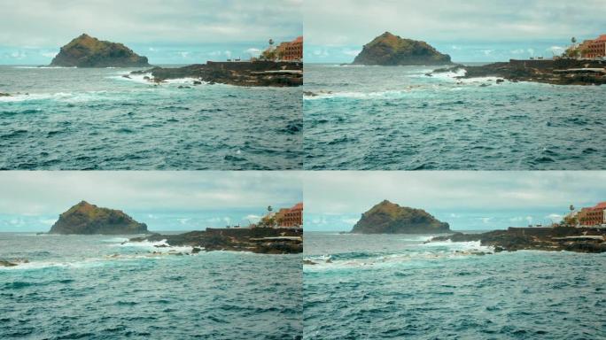 加那利群岛西部的海湾。海洋中的一块大石头岩石，海浪拍打着白色泡沫的石头。西班牙加拉奇科