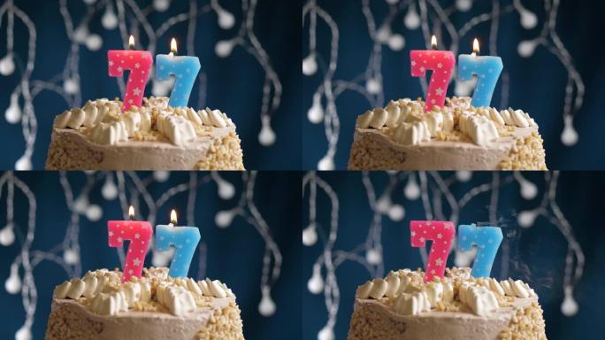 蓝色背景上有77号粉色蜡烛的生日蛋糕。蜡烛吹灭了。慢动作和特写视图