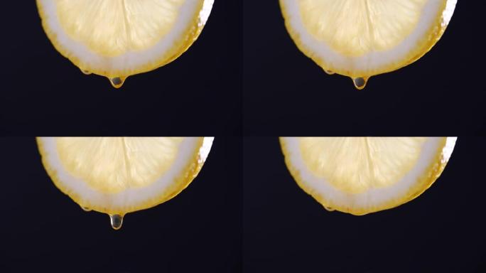 以4k分辨率在黑色背景上慢动作从柠檬切片中滴落的蜂蜜
