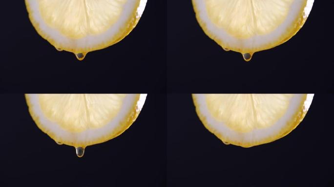 以4k分辨率在黑色背景上慢动作从柠檬切片中滴落的蜂蜜