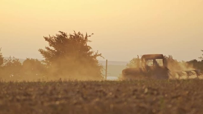 农业机械在自然粉尘背景下耕种土壤。