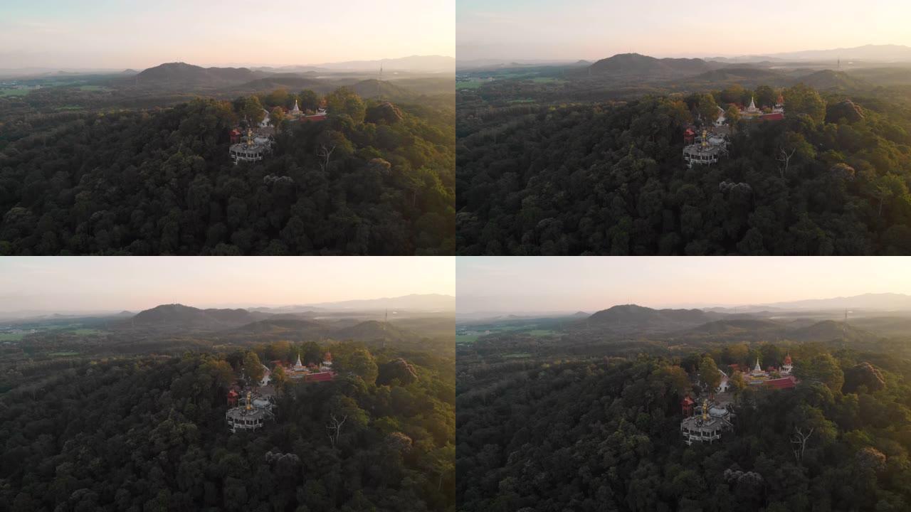 4k空中无人机拍摄的泰国金色雕像和山顶上的白色寺庙宝塔，佛教圣地，相信冥想，日落黄金时刻，平静的宁静