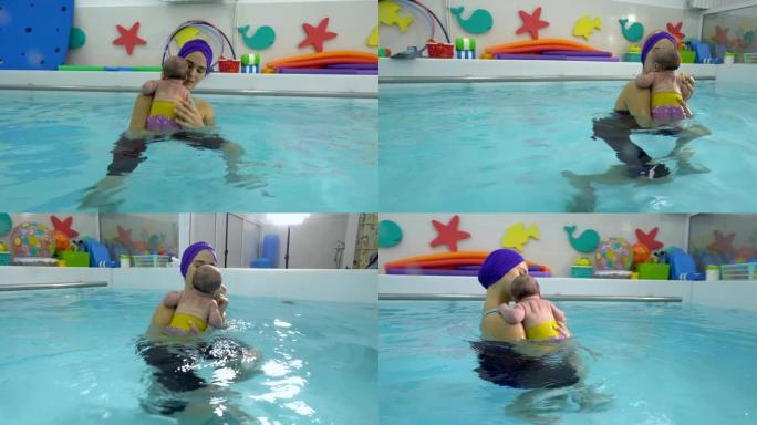 一位年轻的母亲抱着一个新生婴儿，并在儿童游泳池中游泳。婴儿健康游泳。特写。4K