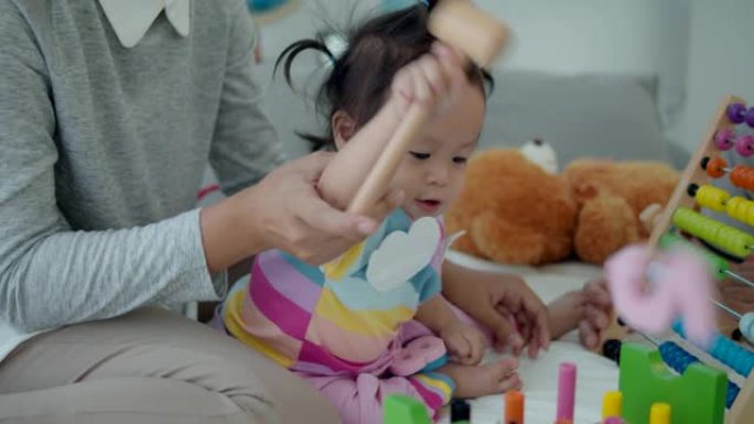 4k慢动作，亚洲家庭与女婴玩木制多色玩具。婴儿概念教育。