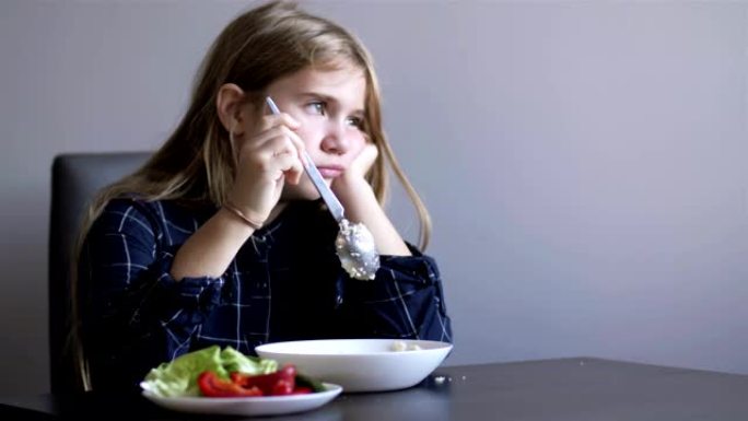 小女孩不想吃蔬菜。孩子生气并转身离开