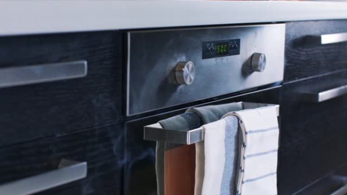 从不锈钢电烤箱中冒出来的白烟特写。库存镜头。现代厨房电器