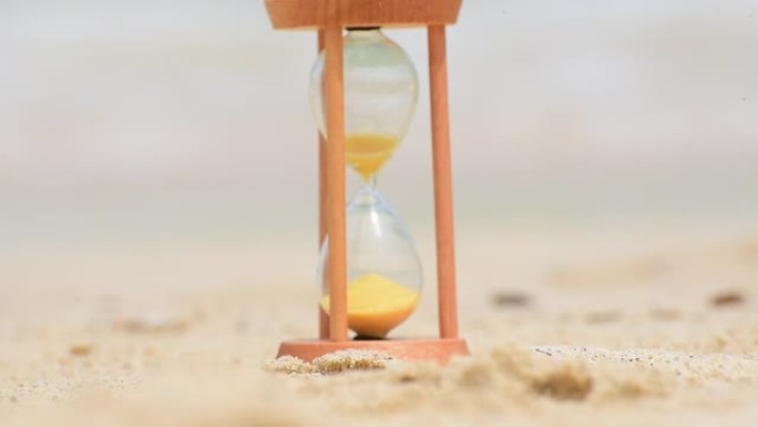 热带沙滩时间仪器上的沙漏时钟。在阳光明媚的日子里，观看钟表过去的历史老式埋葬在海滩上。
