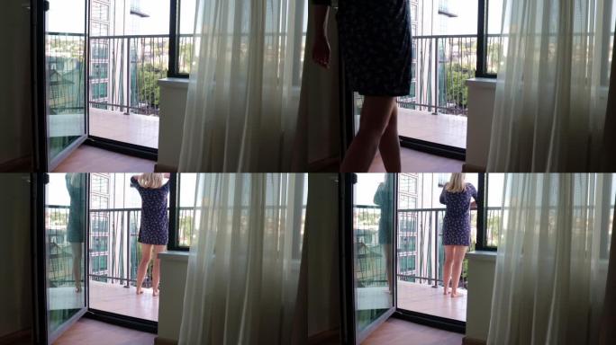 穿着短裙的女人在夏天的早晨出现在阳台上，抚摸着她的头发，看着远处的天气