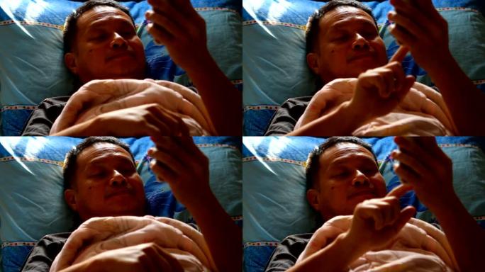 泰国男子在床上玩智能手机