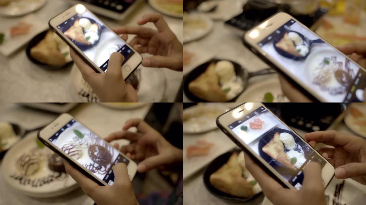 年轻的亚洲女人在桌子上用手机拍照冰淇淋布朗尼。