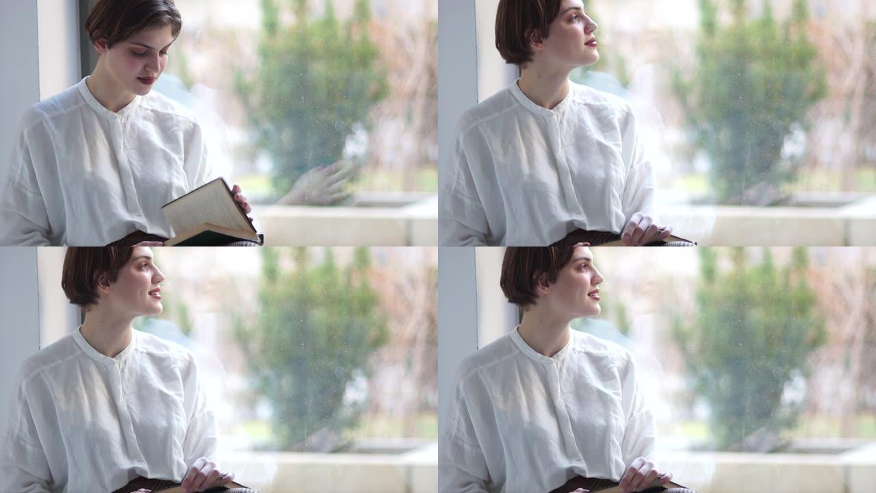 一个短发女孩的近照是坐在窗台上读一本旧书。快乐的女人